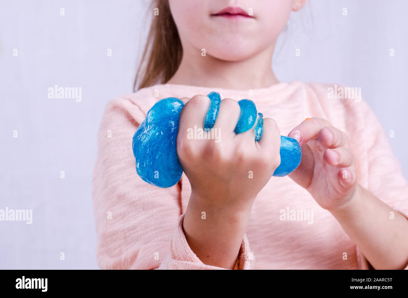 Cute little girl holding jouet Slime, dans le monde entier l a fait jouet.  Enfant jouant avec slime squeeze et l'étirer Photo Stock - Alamy