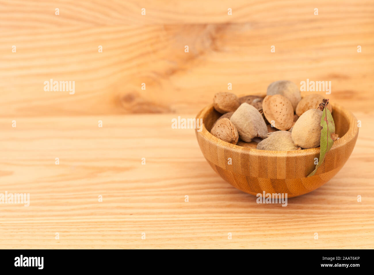 Amandes en coque bol en bois sur table en bois. Concept d'amande avec copyspace. Banque D'Images