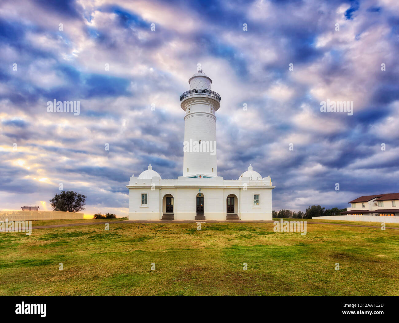 Façade du premier phare australienne Macquarie à Sydney contre ciel nuageux au lever du soleil - monument historique construit de pierres blanches. Banque D'Images