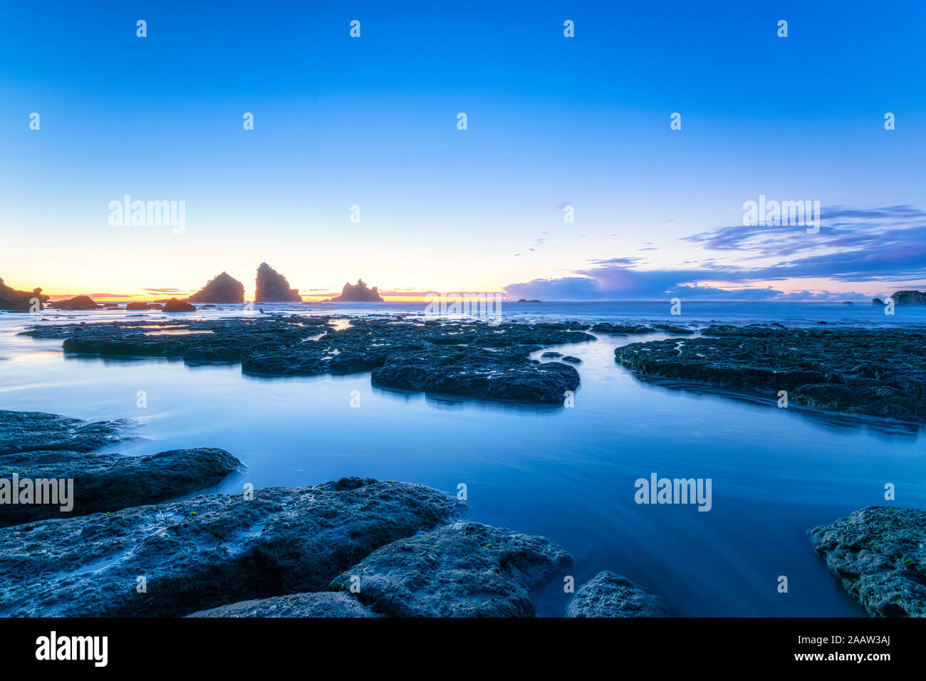 Nouvelle Zélande, île du Sud, côte de la mer de rochers au crépuscule avec Motukiekie Beach sea stacks à distance Banque D'Images