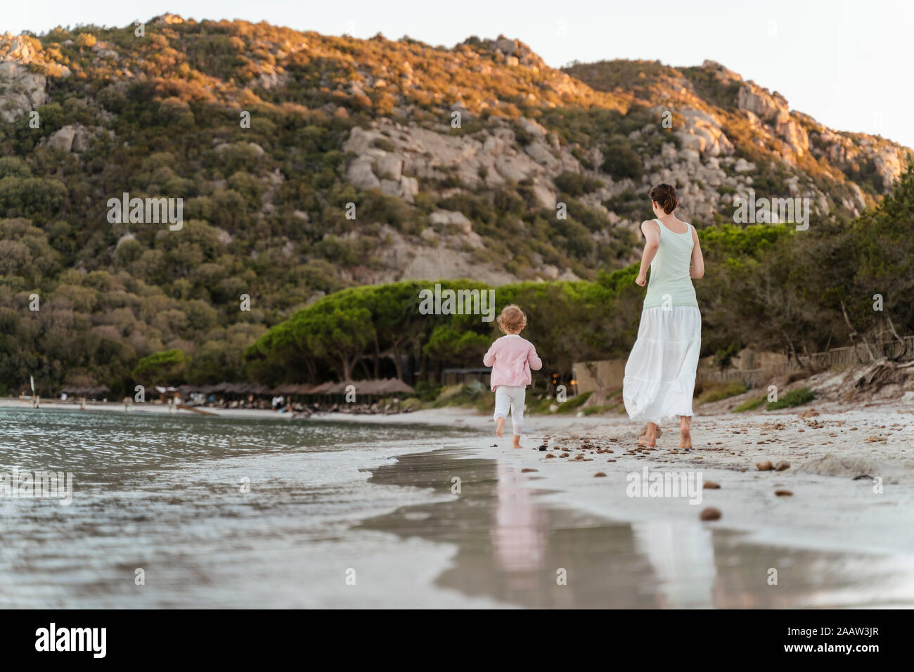 Vue arrière de l'exécution de la mère et sa fille sur la plage Banque D'Images