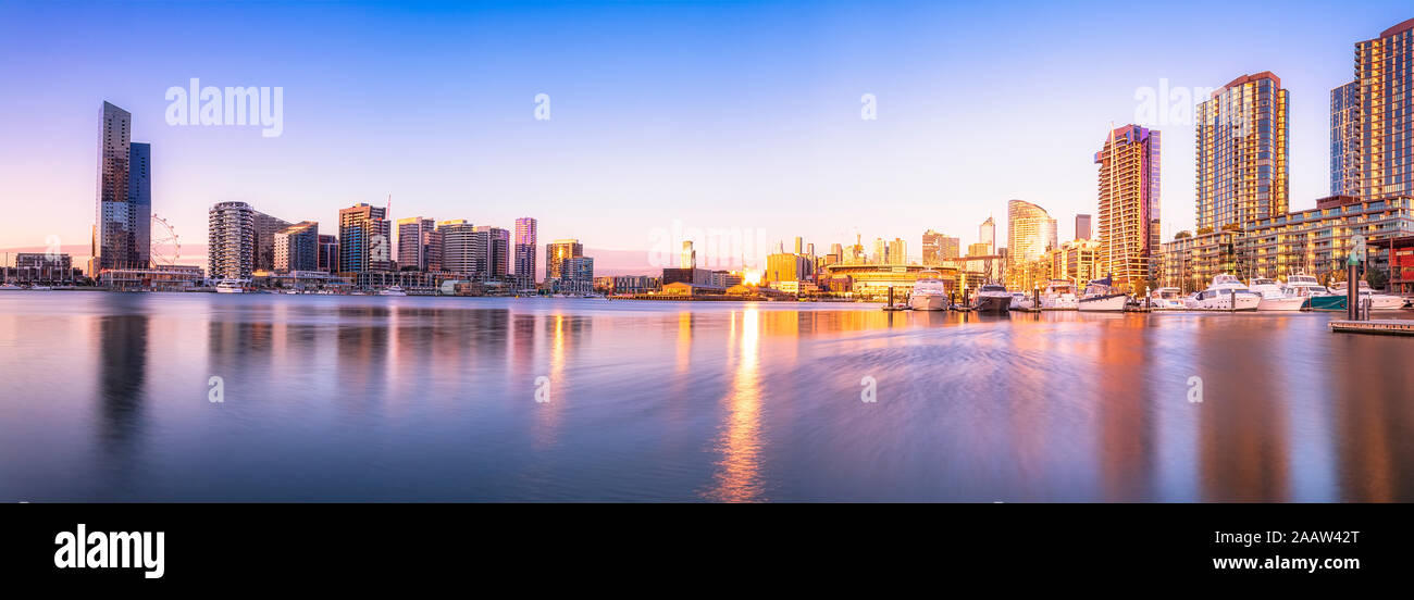 Les bâtiments modernes en face de la rivière Yarra au Melbourne Docklands contre le ciel au coucher du soleil, Victoria, Australie Banque D'Images