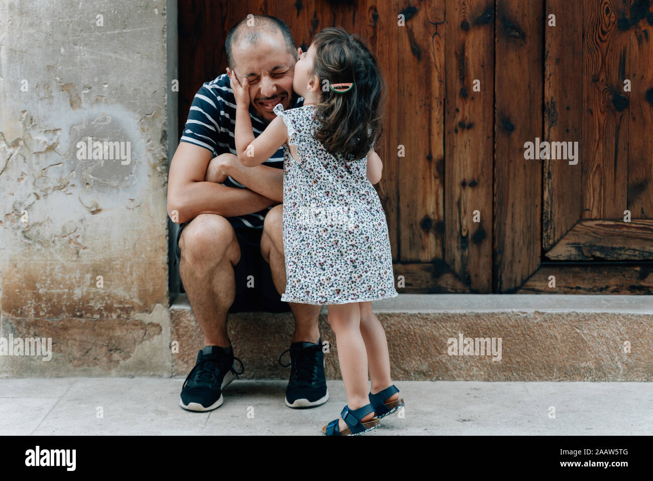 Little girl kissing son père à l'extérieur, Mallorca, Espagne Banque D'Images