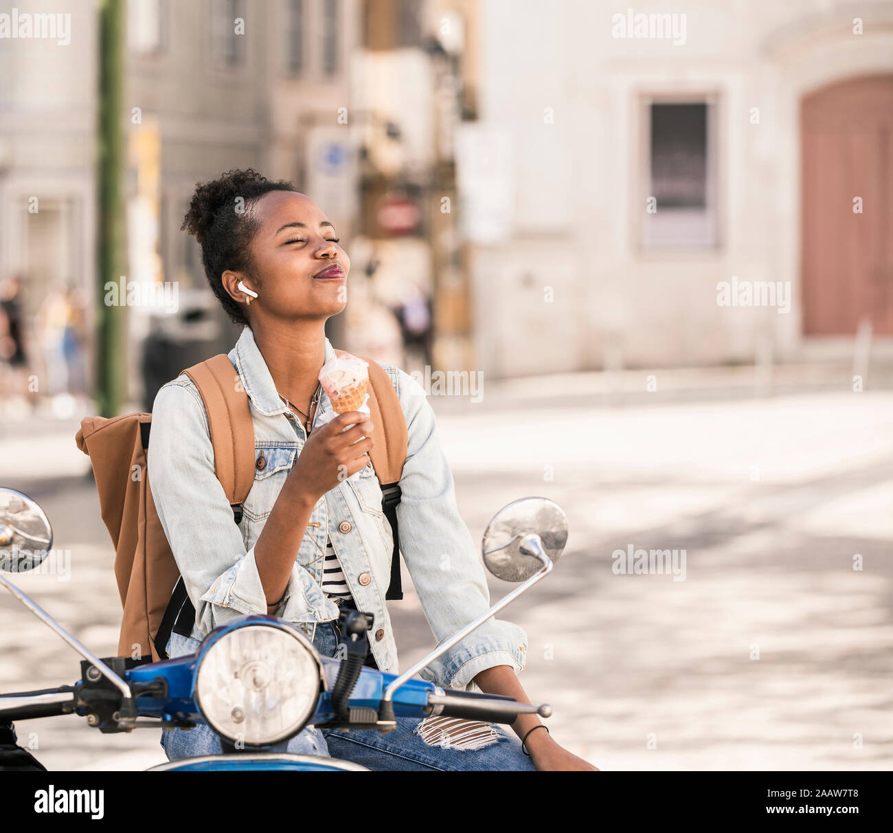 Happy young woman with scooter tout en étant dans la ville, Lisbonne, Portugal Banque D'Images
