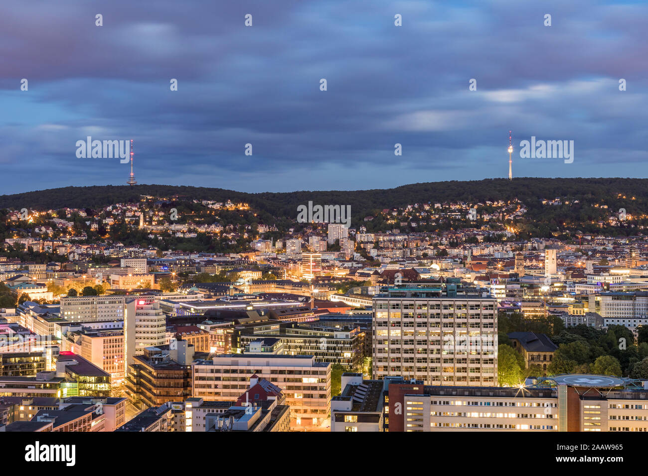 Les bâtiments illuminés et tour de communications contre ciel nuageux au crépuscule à Stuttgart, Allemagne Banque D'Images