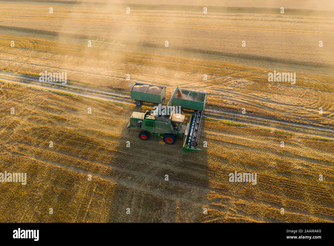 Vue aérienne de la moissonneuse-batteuse, sur le domaine agricole pendant le coucher du soleil Banque D'Images Vue aérienne de la moissonneuse-batteuse, sur le domaine agricole pendant le coucher du soleil Banque D'Images