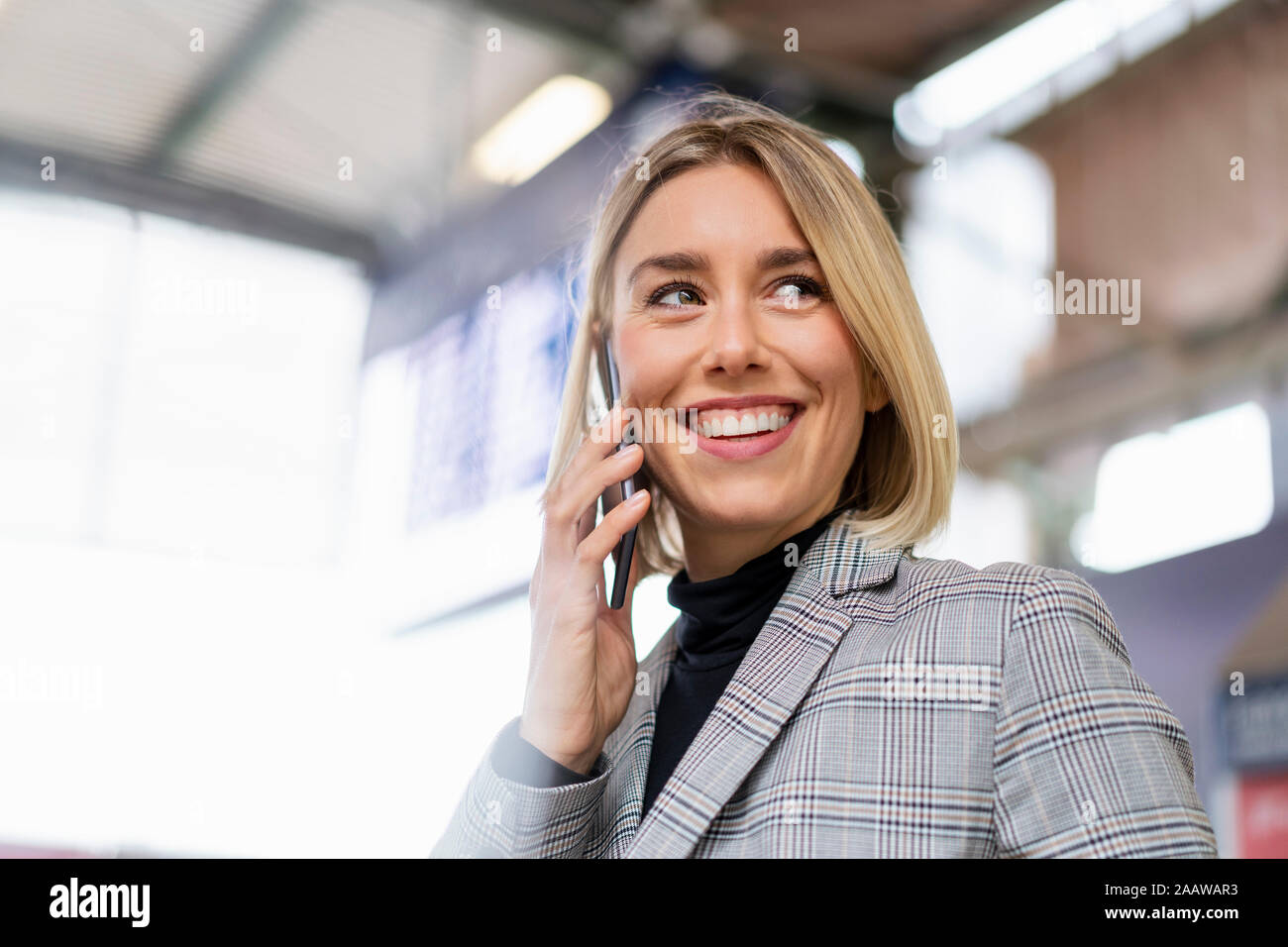 Happy young businesswoman au téléphone à la gare Banque D'Images