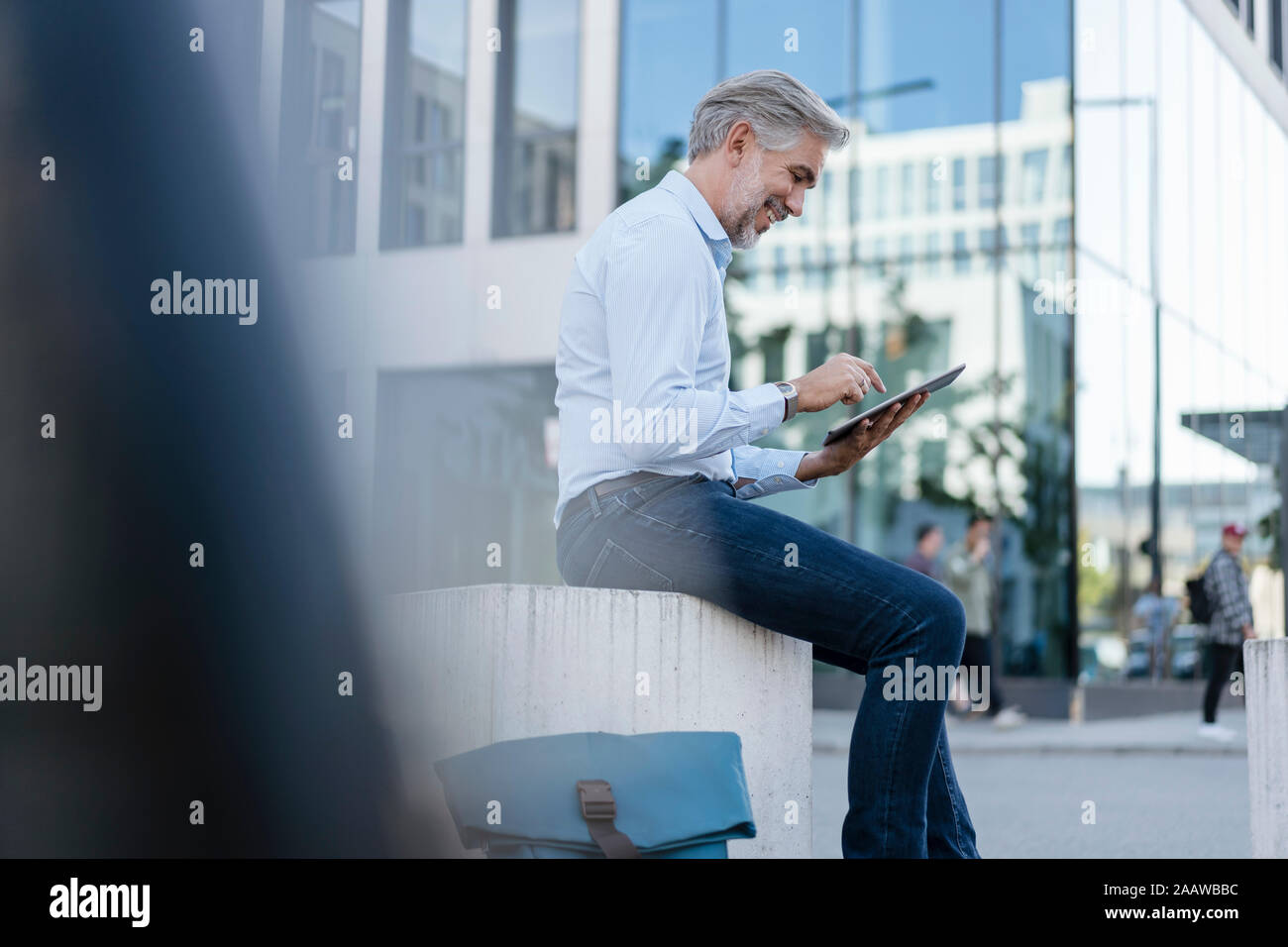 Smiling mature businessman using tablet dans la ville Banque D'Images