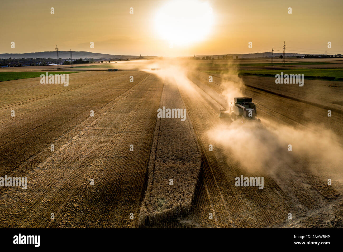 Vue aérienne de la moissonneuse-batteuse, sur le domaine agricole contre le ciel au coucher du soleil Banque D'Images