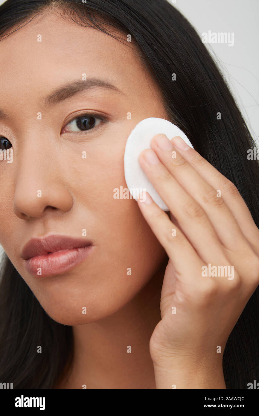 Portrait of young female femme chinoise, en utilisant un coton Banque D'Images
