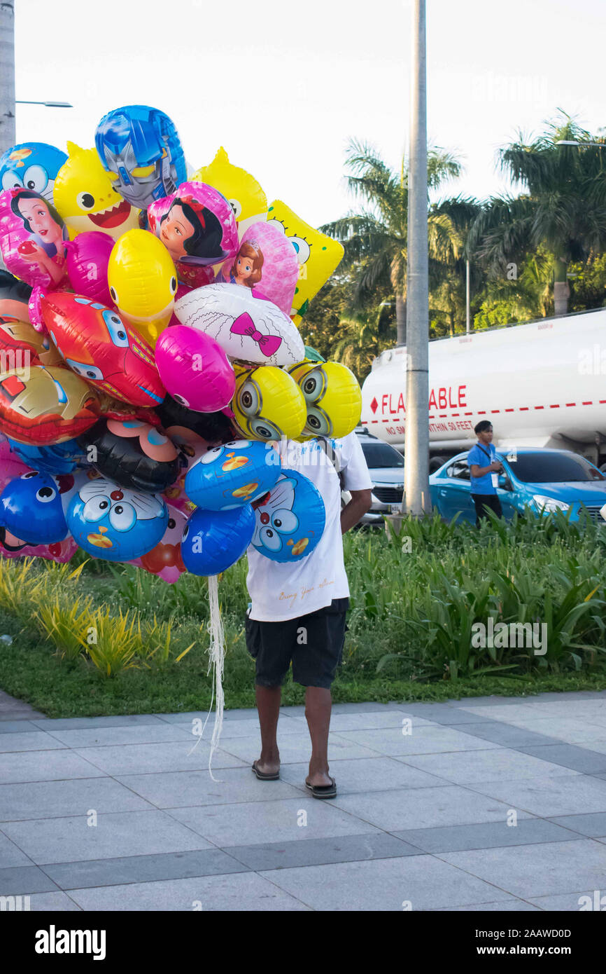 OCT. 26, 2019-Manille PHILIPPINES : Homme de vendre un tas de ballons de formes différentes et des caractères de film Banque D'Images