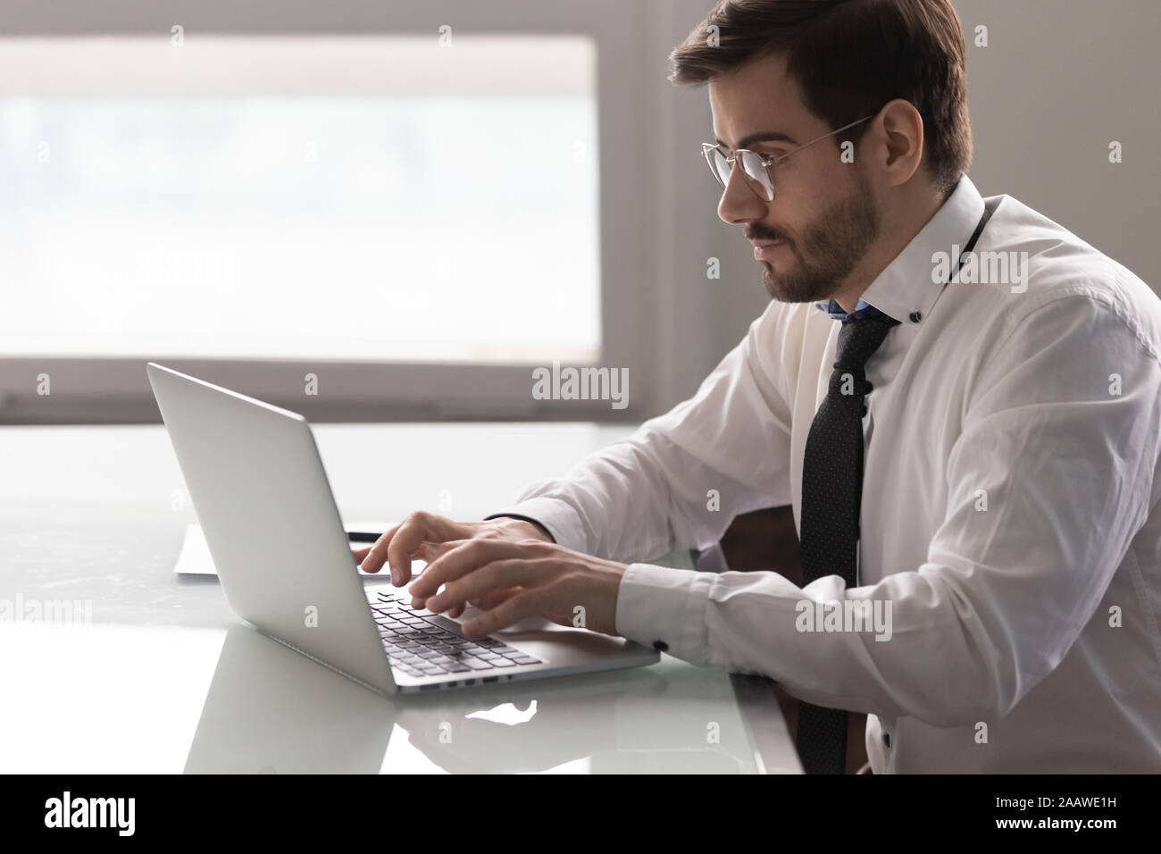 Concentrés employés masculins occupés à travailler à l'ordinateur portable Banque D'Images
