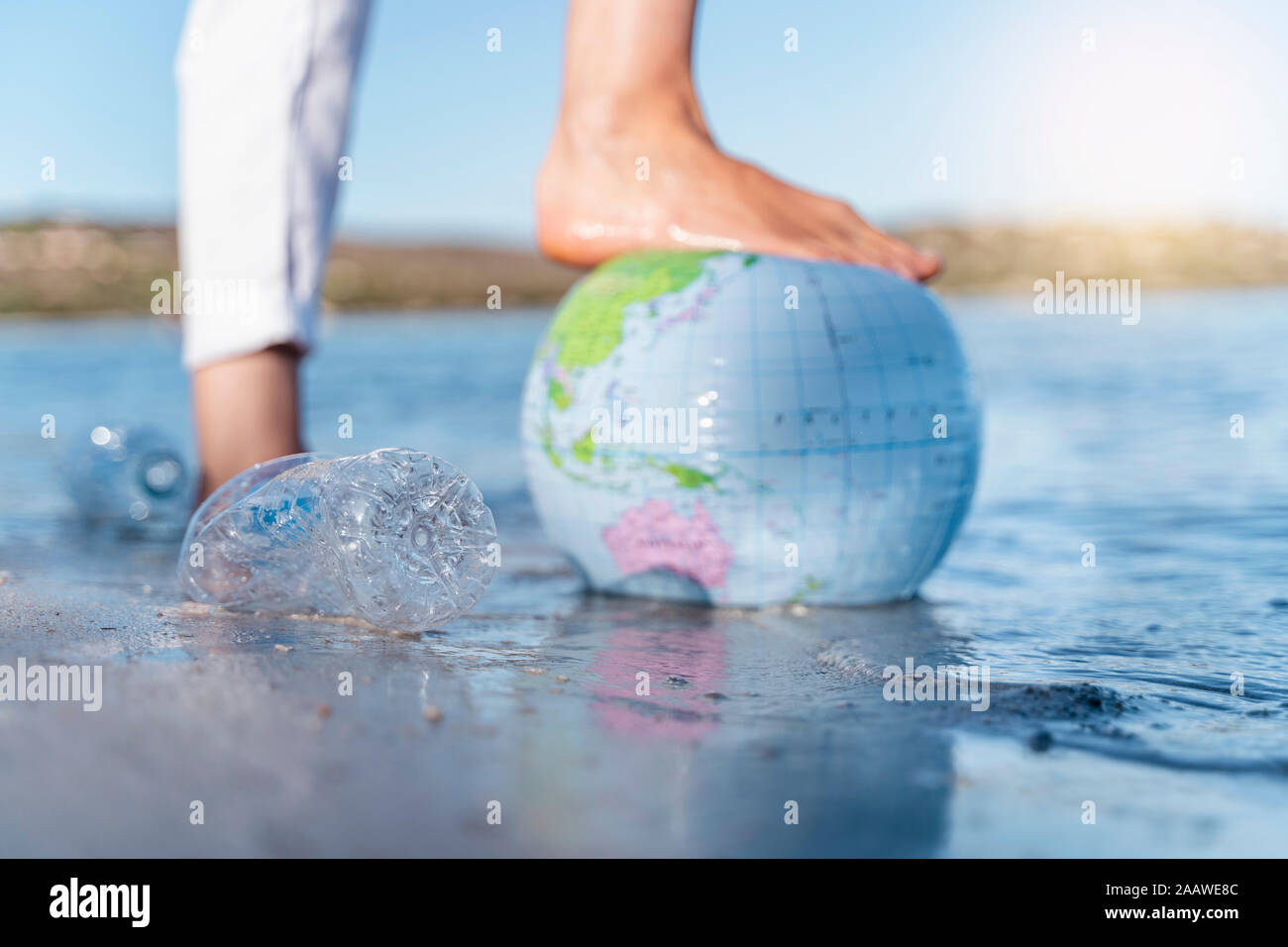 Le pied de l'homme sur terre de ballons de plage, close-up Banque D'Images