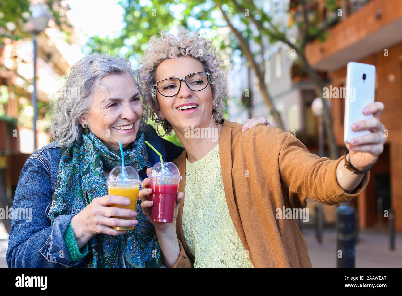 Maman avec ses supérieurs en tenant sa fille adulte dans la ville selfies Banque D'Images