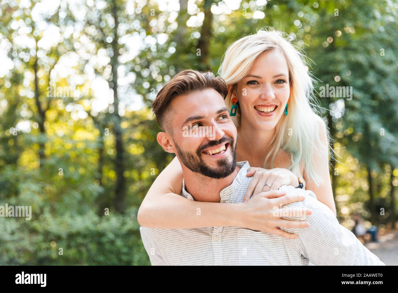 Portrait of happy young man giving his girlfriend a piggyback ride Banque D'Images