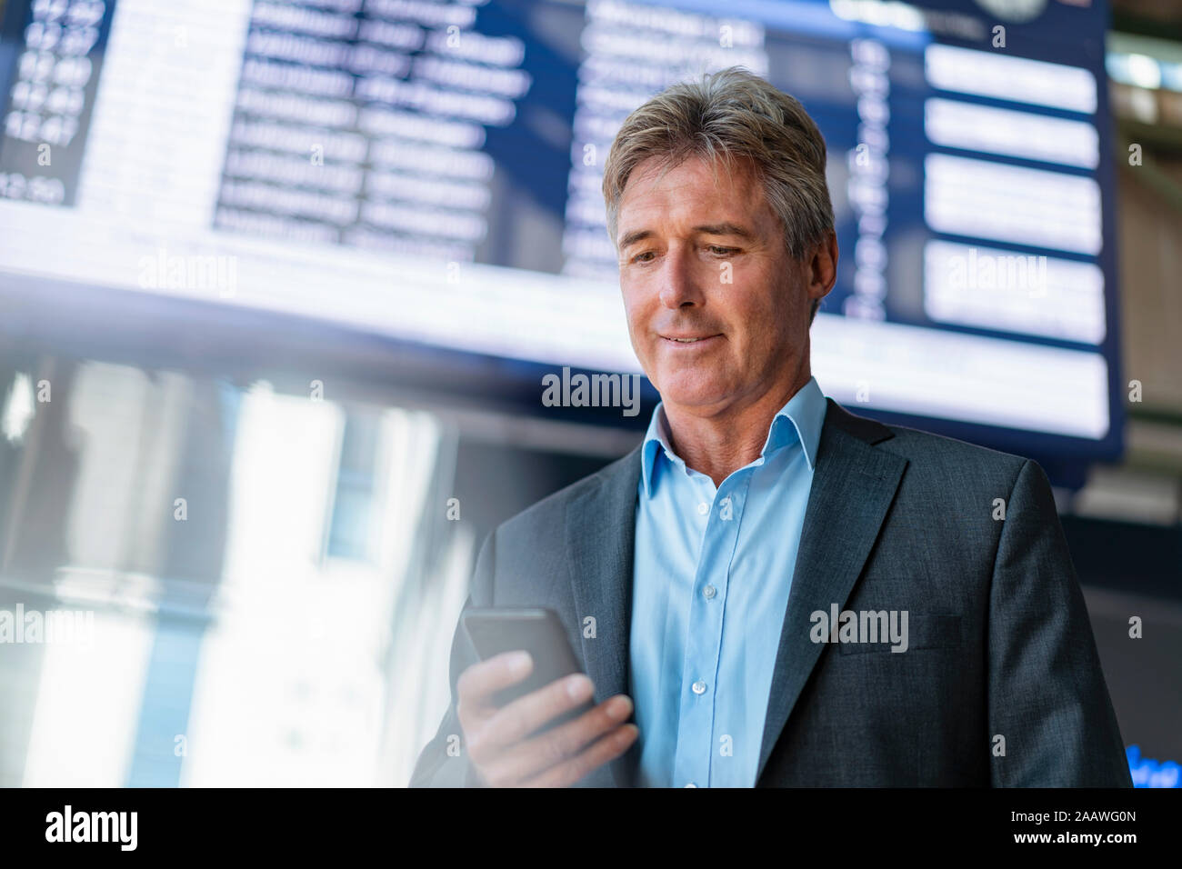 Mature businessman using cell phone à la gare Banque D'Images