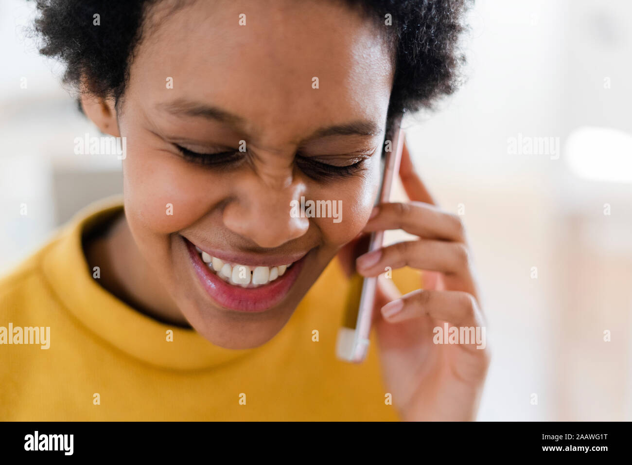 Heureux jeune femme au téléphone à la maison Banque D'Images