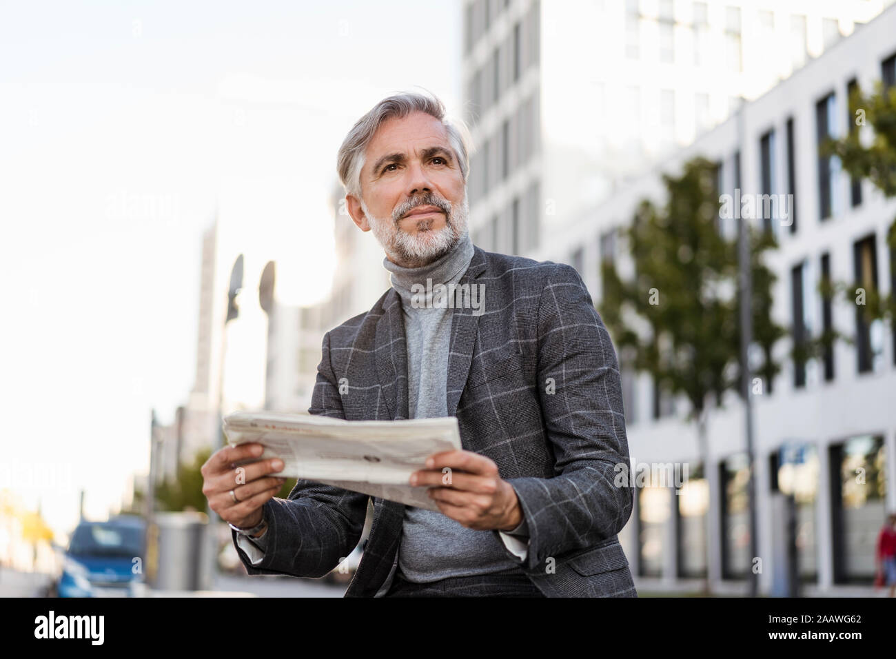 La mode mature businessman reading newspaper in the city Banque D'Images