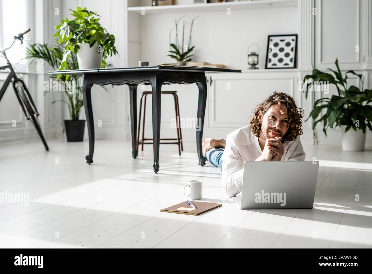 Homme étendu sur le sol à l'aide d'ordinateur portable Banque D'Images
