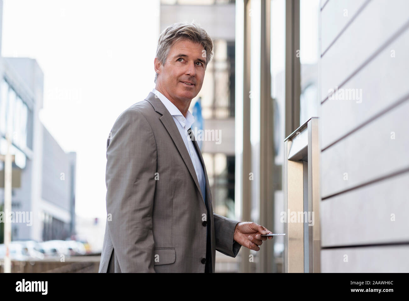 Mature businessman le retrait d'argent à un guichet automatique Banque D'Images