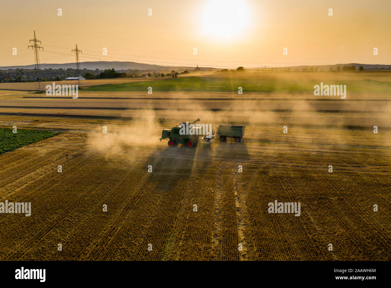 Vue aérienne de la moissonneuse-batteuse, sur le domaine agricole contre le ciel au coucher du soleil Banque D'Images