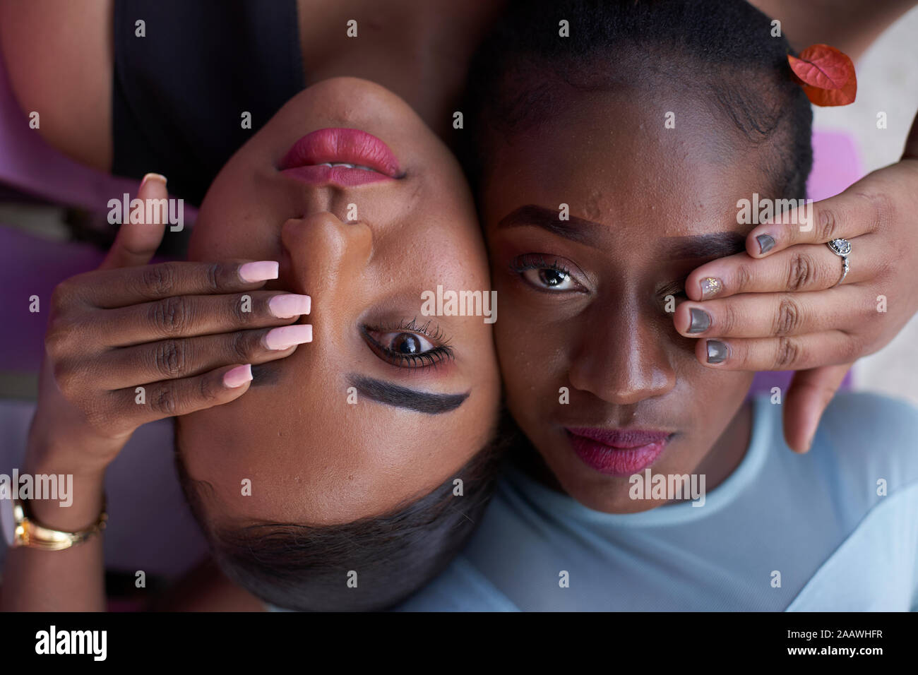 Portrait de deux jeunes femmes tête à tête couvrant les yeux avec les mains Banque D'Images