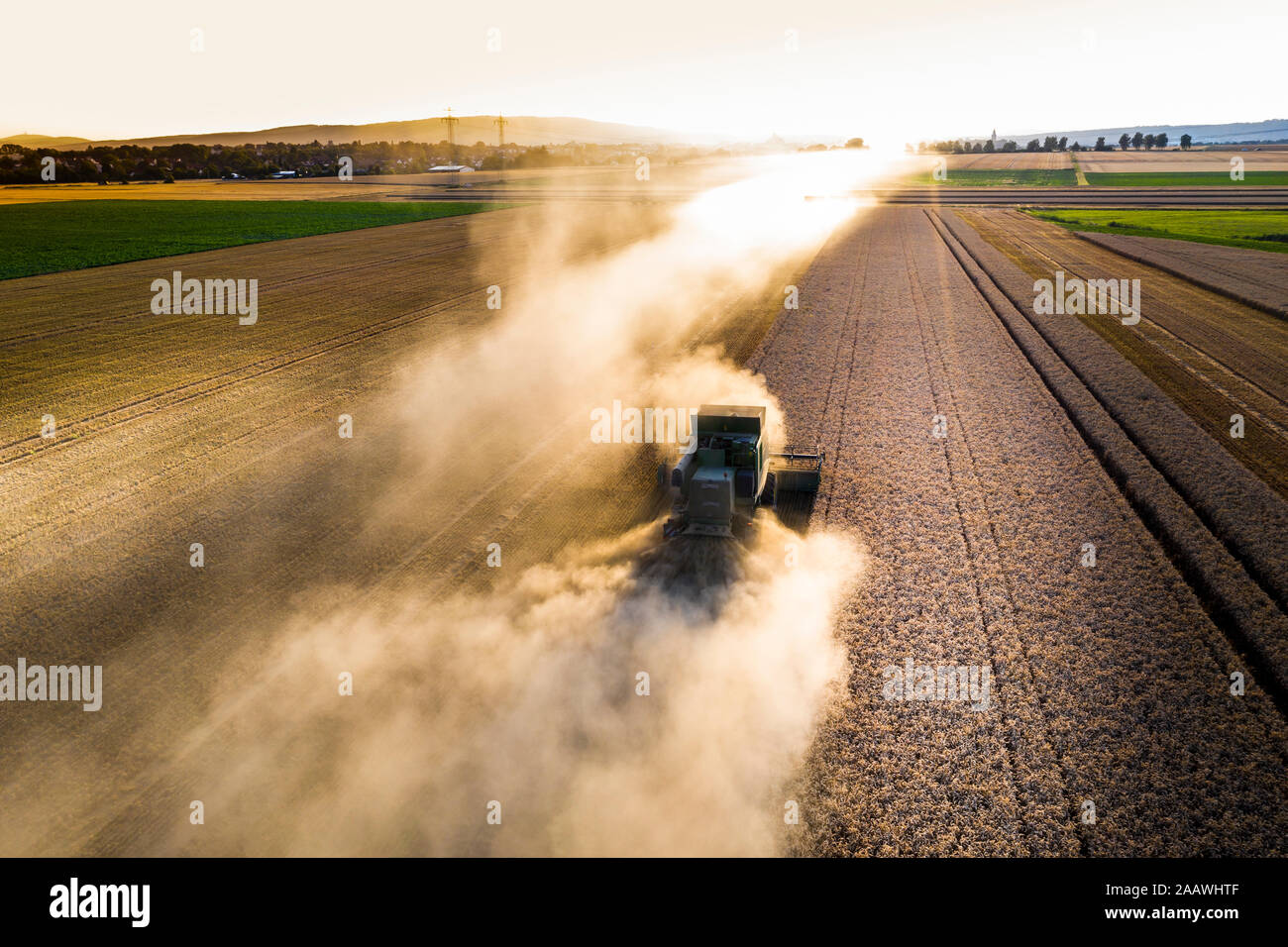 Vue aérienne de la moissonneuse-batteuse, sur le domaine agricole contre le ciel au coucher du soleil Banque D'Images