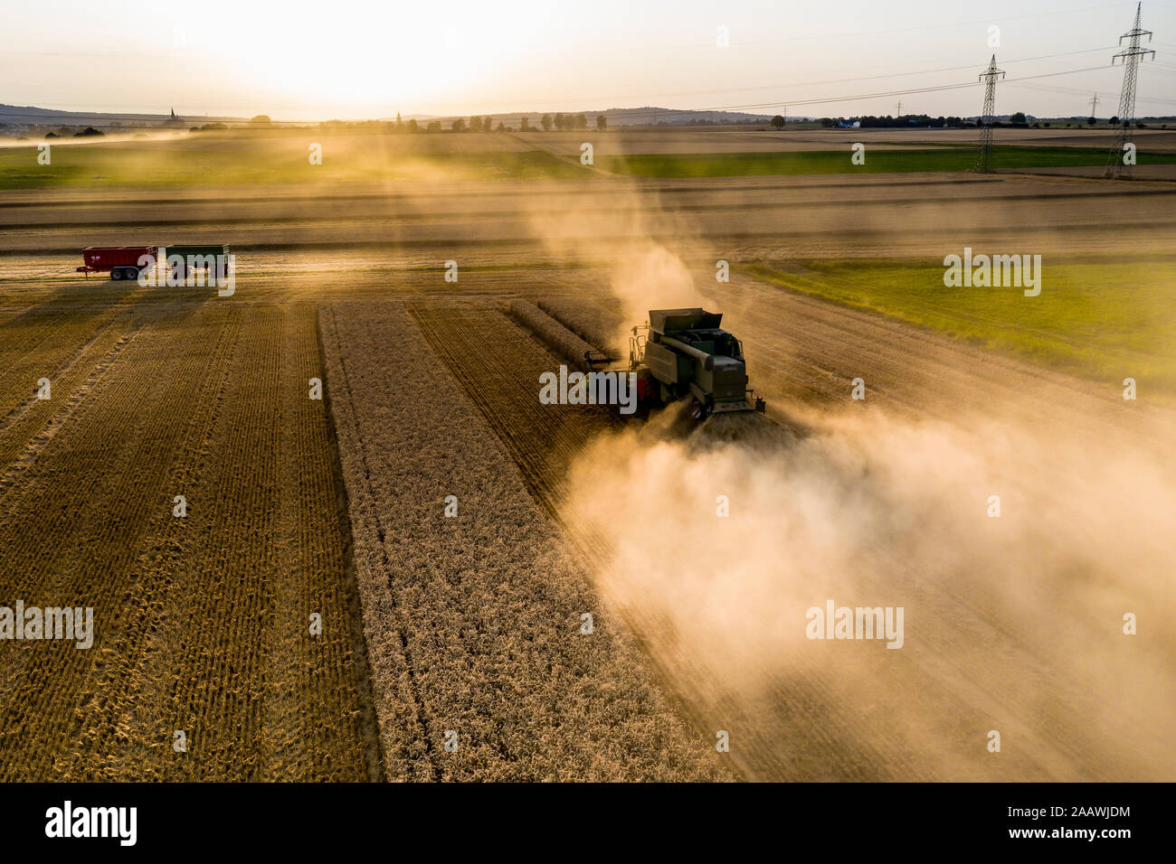 Vue aérienne de la moissonneuse-batteuse, sur le domaine agricole contre le ciel au coucher du soleil Banque D'Images