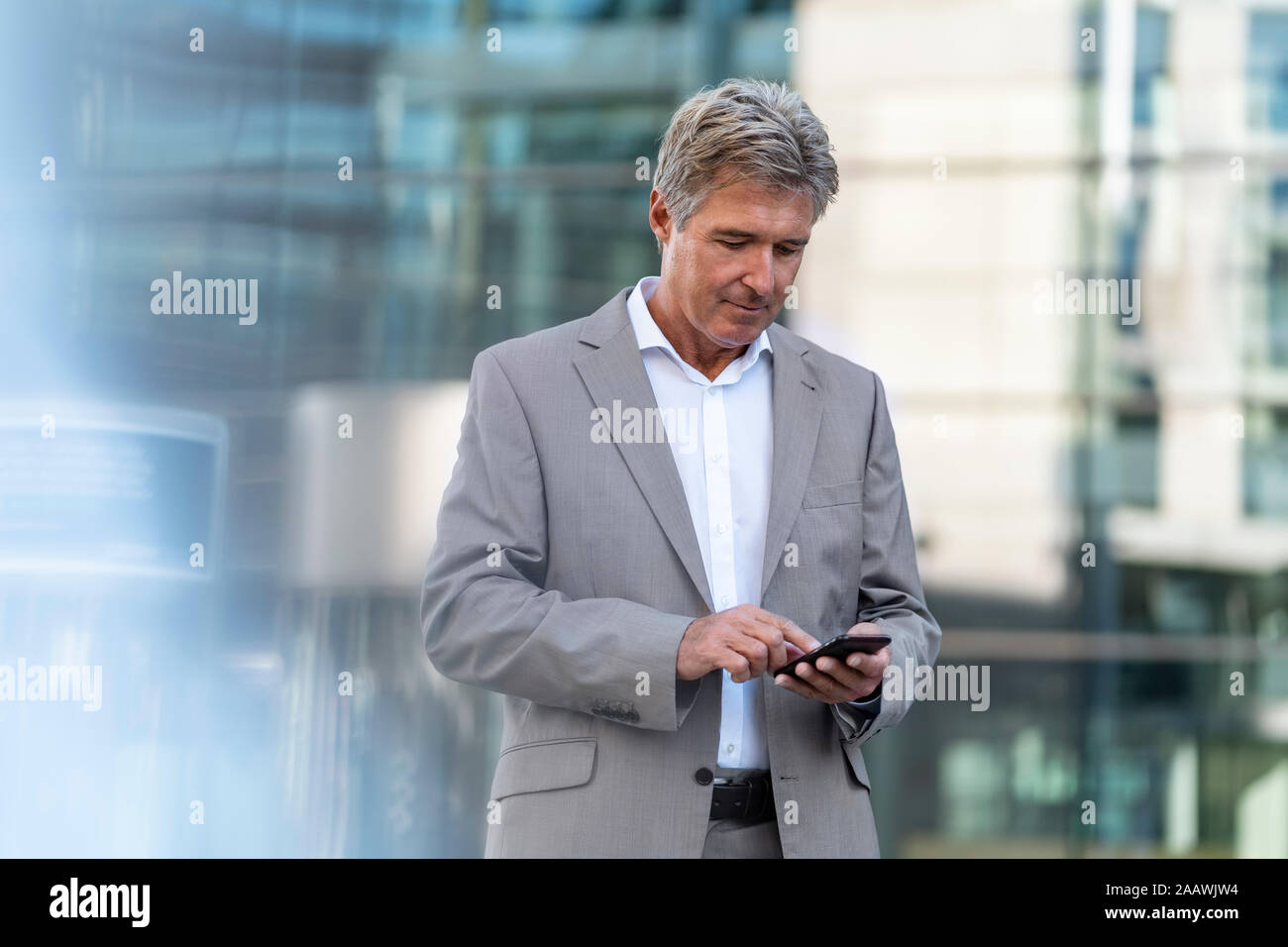 Mature businessman using cell phone dans la ville Banque D'Images