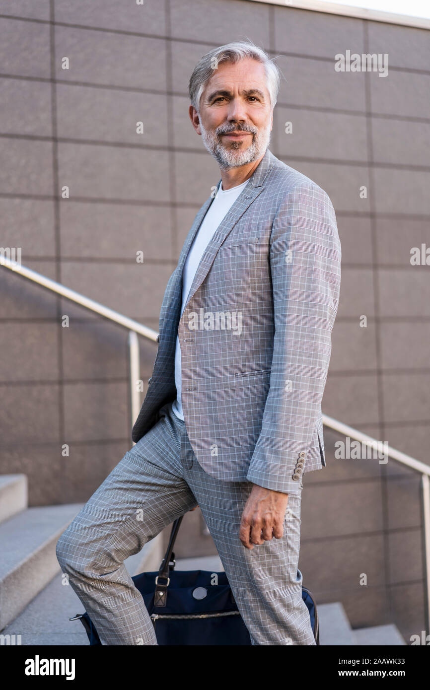 Portrait of mature businessman à la mode avec un sac dans les escaliers Banque D'Images