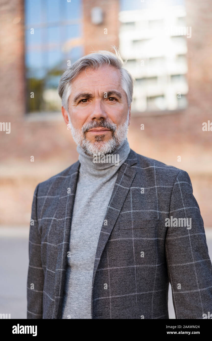 Portrait of mature businessman à la mode à un bâtiment en brique Banque D'Images
