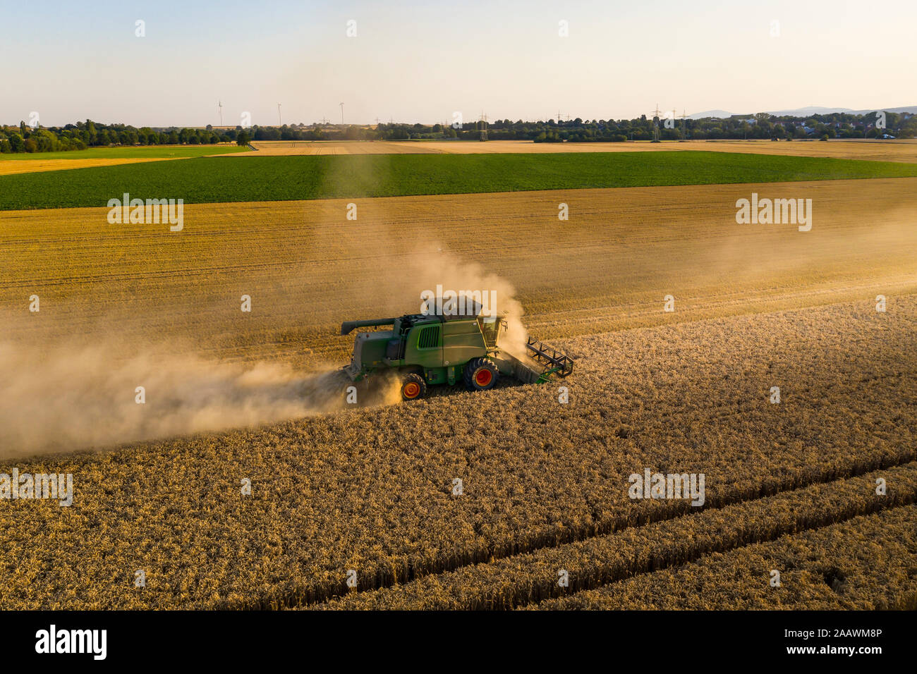 Vue aérienne de la moissonneuse-batteuse, sur le domaine agricole contre ciel clair pendant le coucher du soleil Banque D'Images