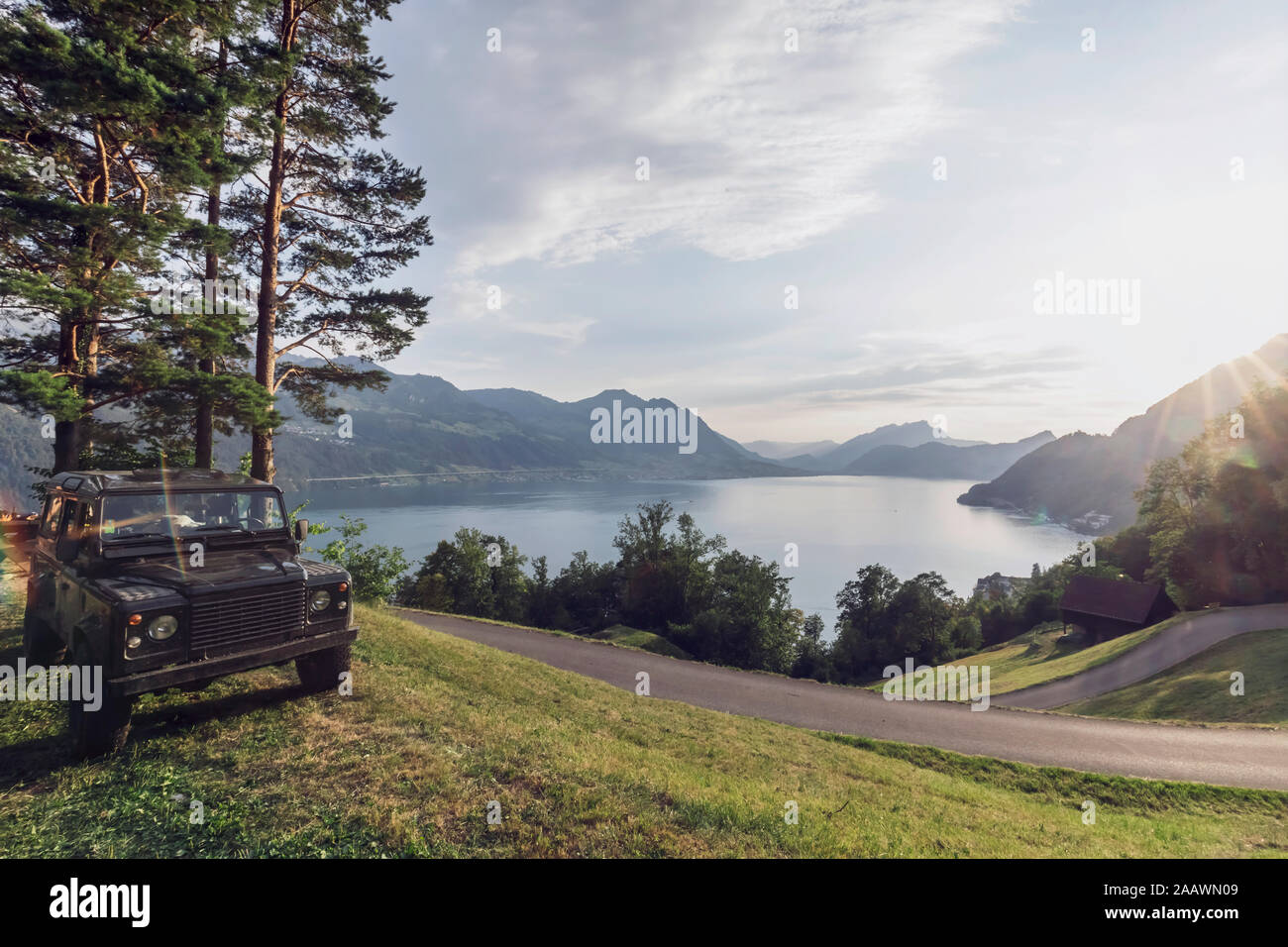 La Suisse, Lucerne, Schwyz, 4x4 voiture stationnée le long de la route sinueuse avec Lac de Lucerne en arrière-plan Banque D'Images