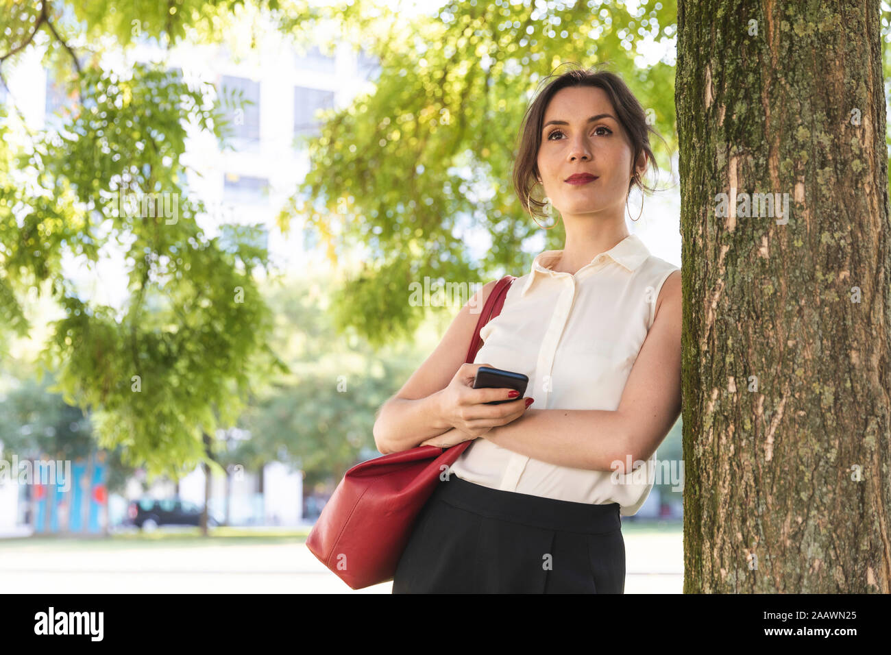 Young businesswoman with cell phone in a park Banque D'Images