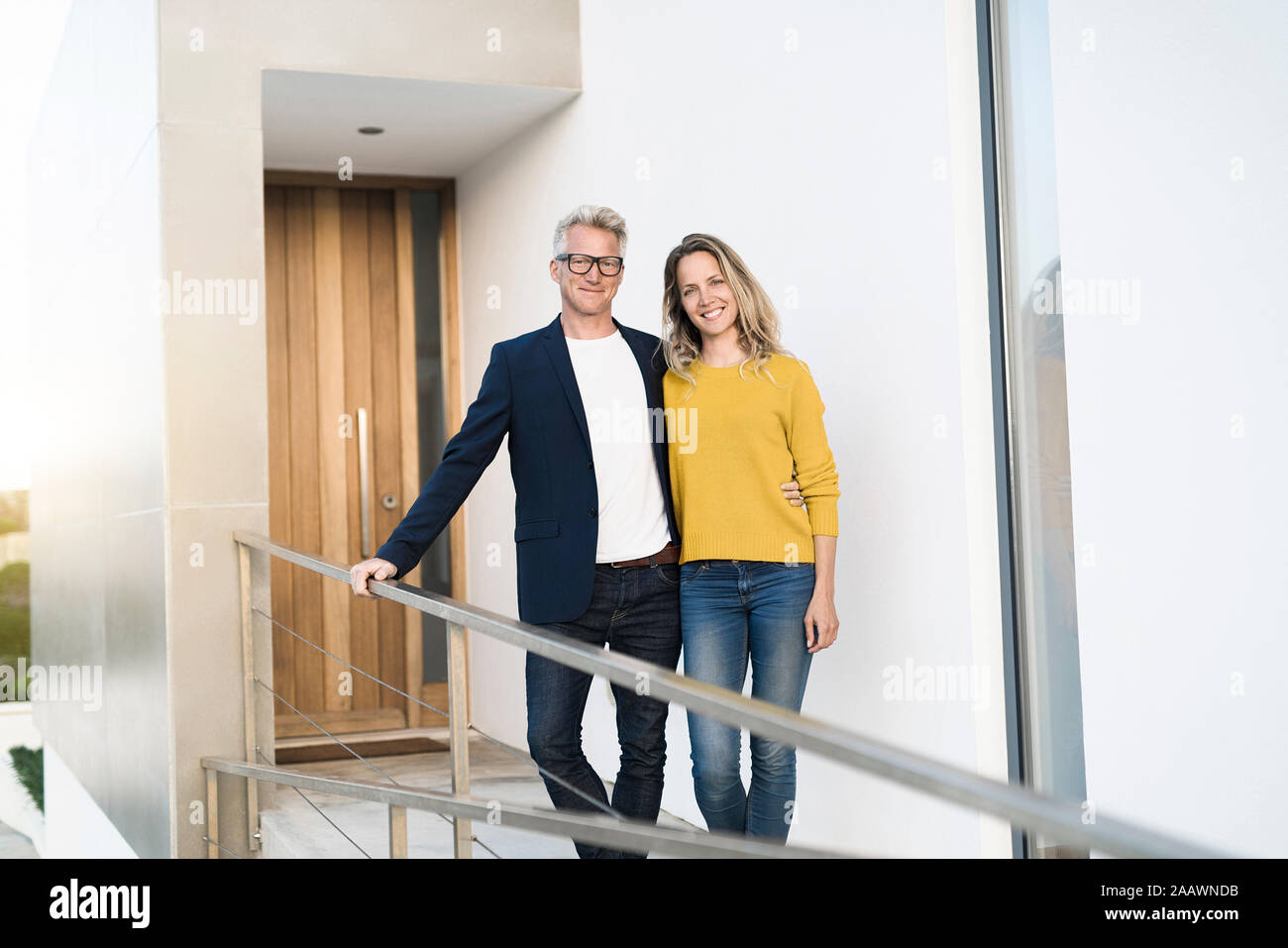 Portrait of smiling couple debout devant leur maison moderne Banque D'Images Portrait of smiling couple debout devant leur maison moderne Banque D'Images