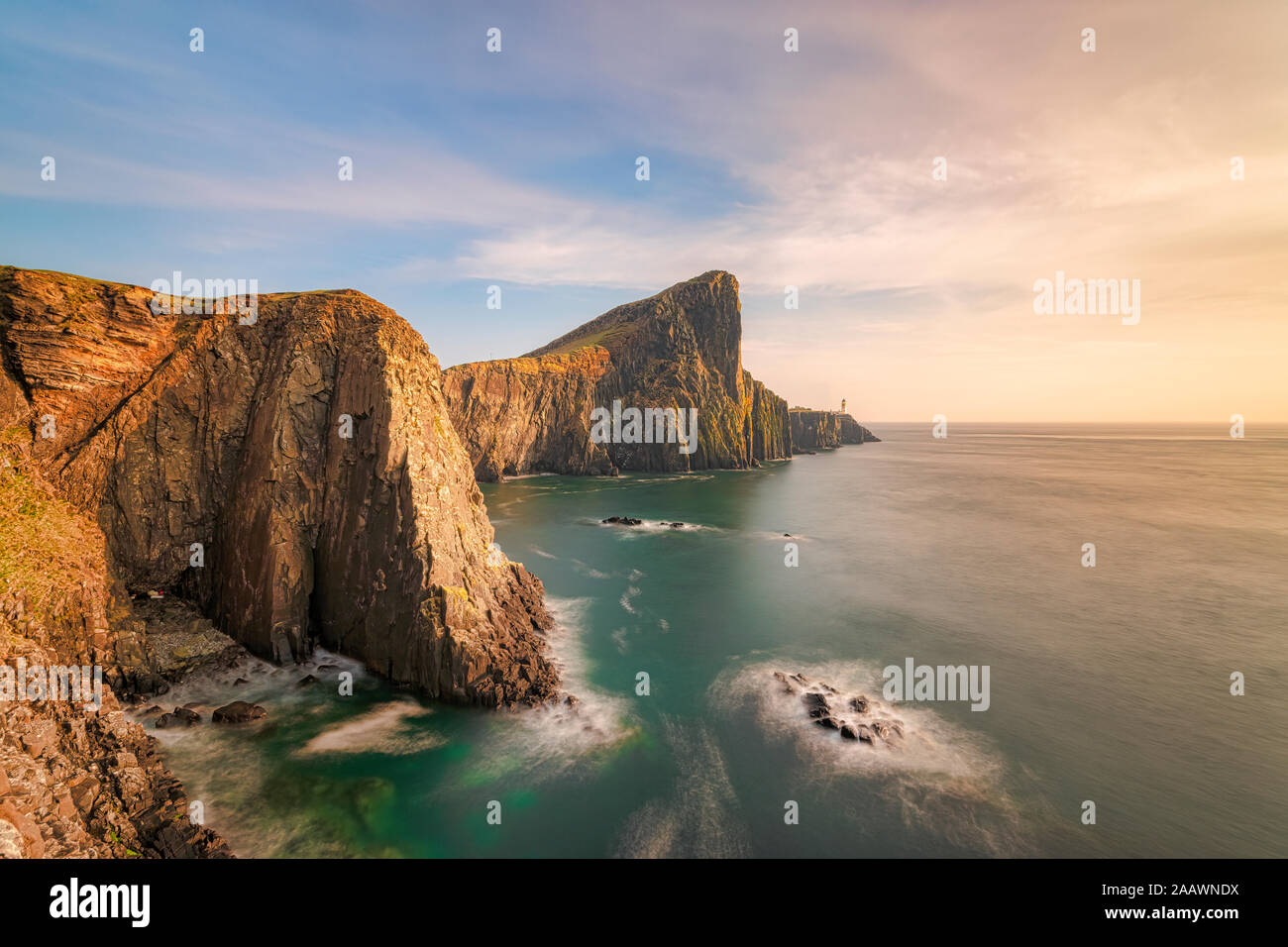 Neist Point Lighthouse par mer contre le ciel au coucher du soleil, Waterstein, île de Skye, Highlands, Scotland, UK Banque D'Images
