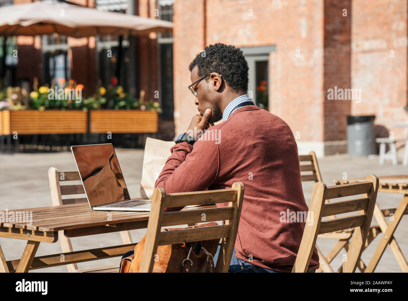 Jeune homme à l'aide d'ordinateur portable dans un café Banque D'Images