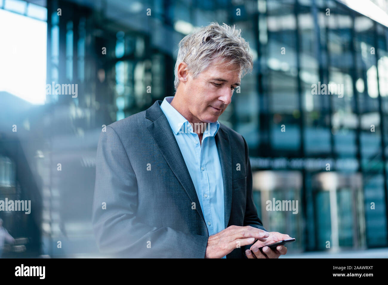 Mature businessman using cell phone dans la ville Banque D'Images