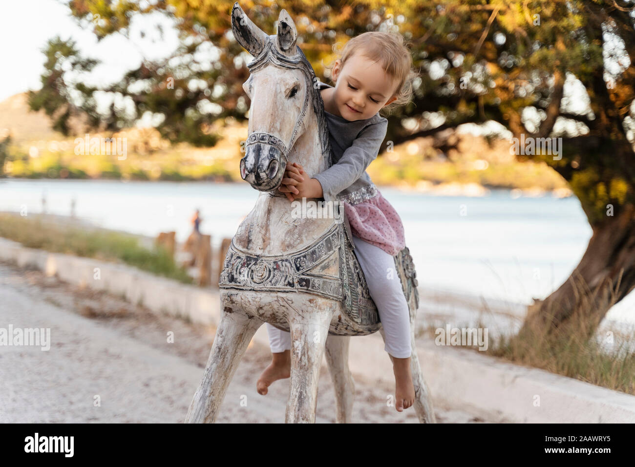 Cute girl sitting on cheval de bois Banque D'Images
