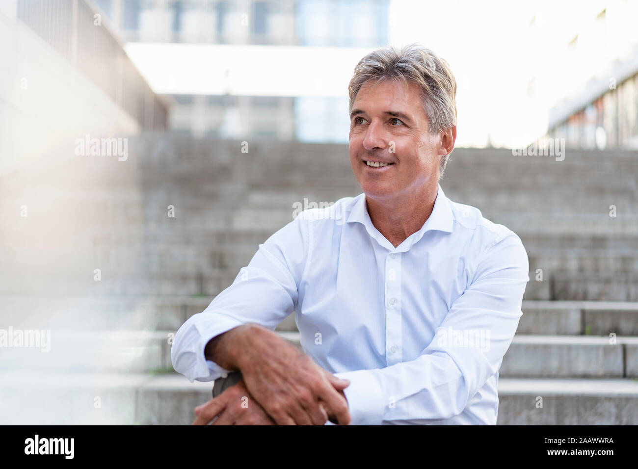 Portrait of mature businessman sitting on stairs Banque D'Images