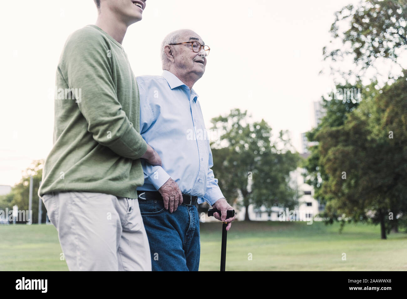 Hauts homme marchant avec l'aide de son petit-fils en park Banque D'Images