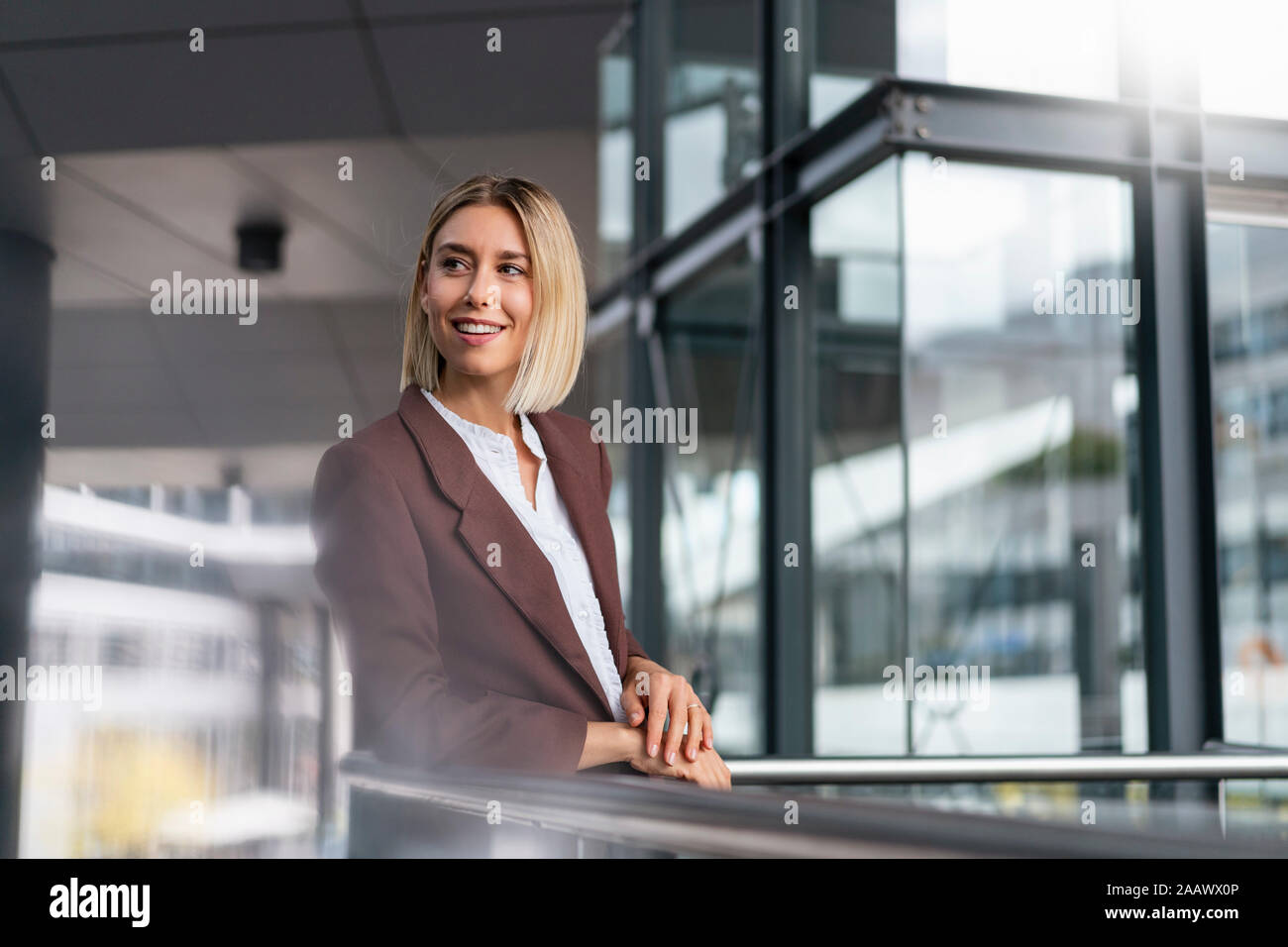 Smiling young businesswoman dans la ville à travers Banque D'Images