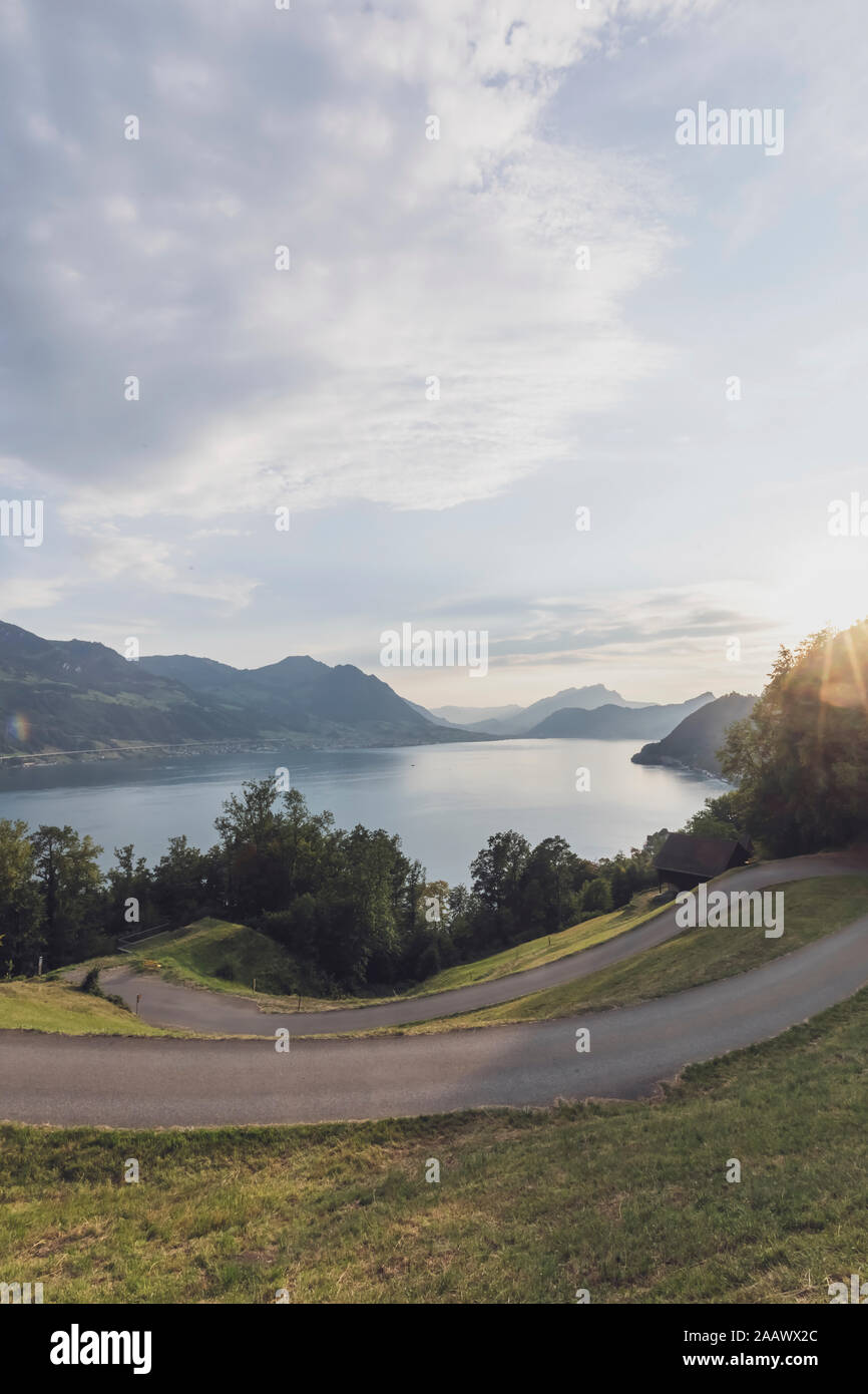 La Suisse, Lucerne, Schwyz, route sinueuse au coucher du soleil avec le lac en arrière-plan Banque D'Images