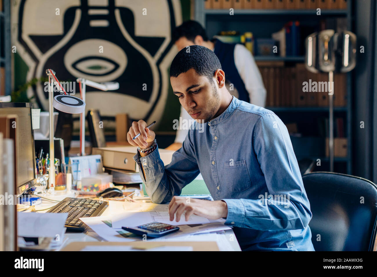 Jeune homme travaillant en bureau d'architecte Banque D'Images