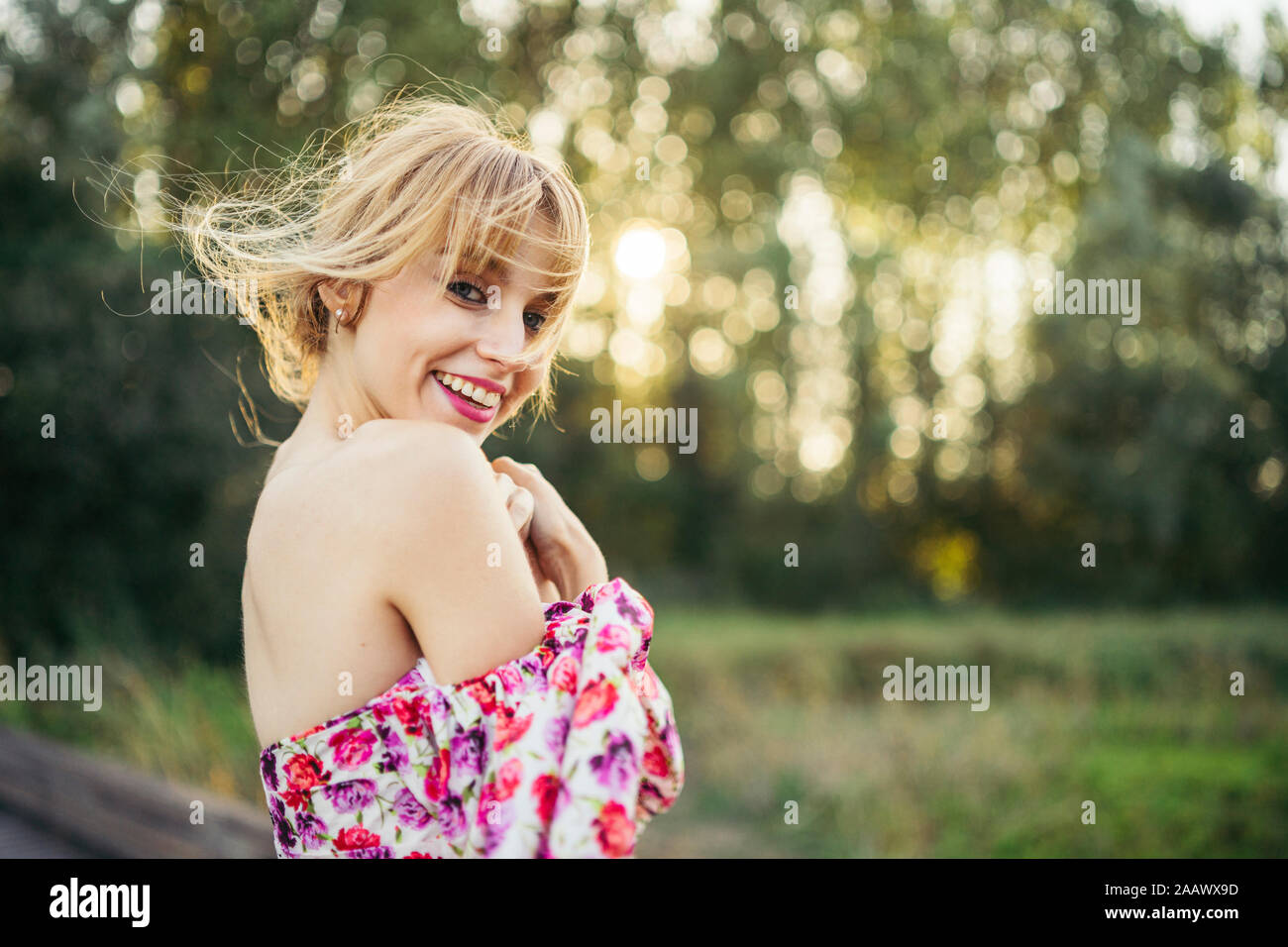 Portrait of happy young woman wearing été Robe avec motif fleuri dans la nature Banque D'Images