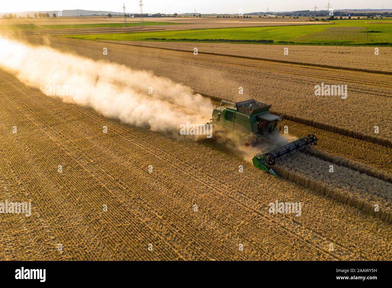 Vue aérienne de la moissonneuse-batteuse, sur le domaine agricole pendant le coucher du soleil Banque D'Images Vue aérienne de la moissonneuse-batteuse, sur le domaine agricole pendant le coucher du soleil Banque D'Images