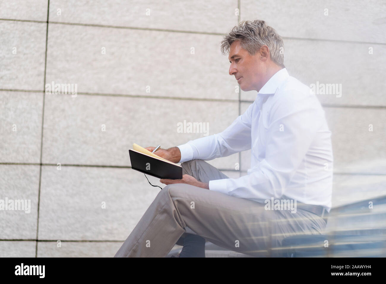 Mature businessman sitting on stairs à ordinateur portable à Banque D'Images