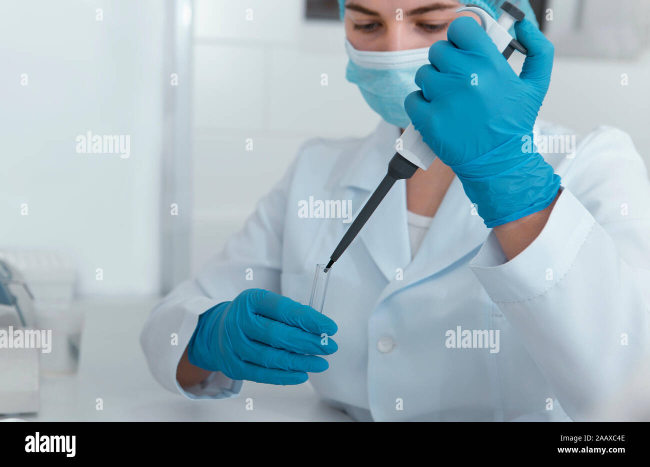 Jeune femme scientifique à grande goutte seringue en tube à essai Banque D'Images