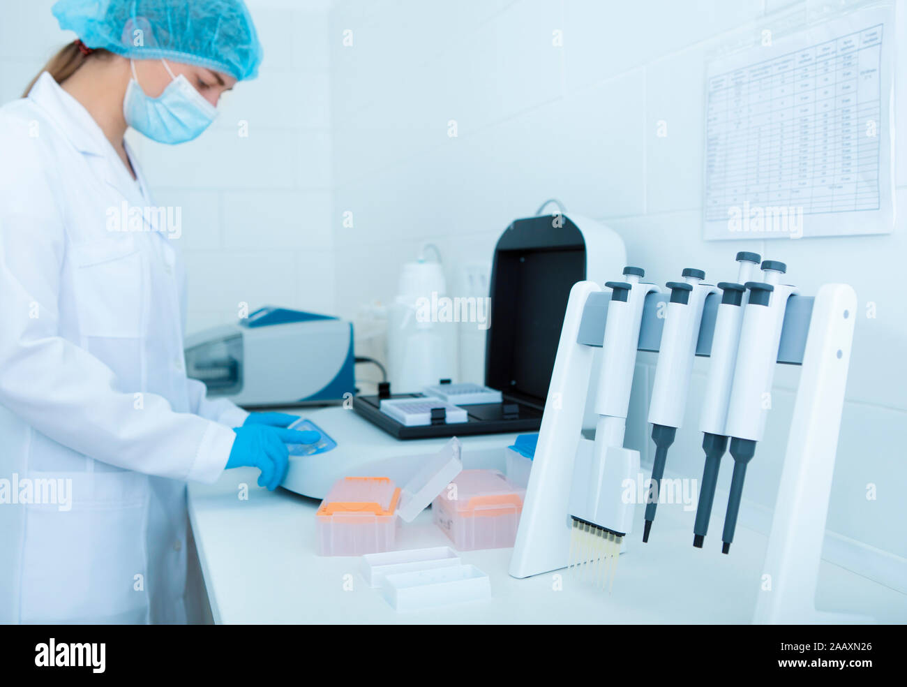 Femme scientifique à l'aide de la machine moderne dans la salle de laboratoire Banque D'Images