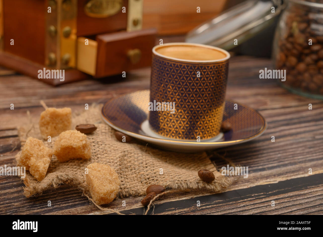 Une tasse de café, des morceaux de sucre dans un sucrier, les grains de café dans un bocal en verre, d'un broyeur de café sur un fond de bois. Close up Banque D'Images